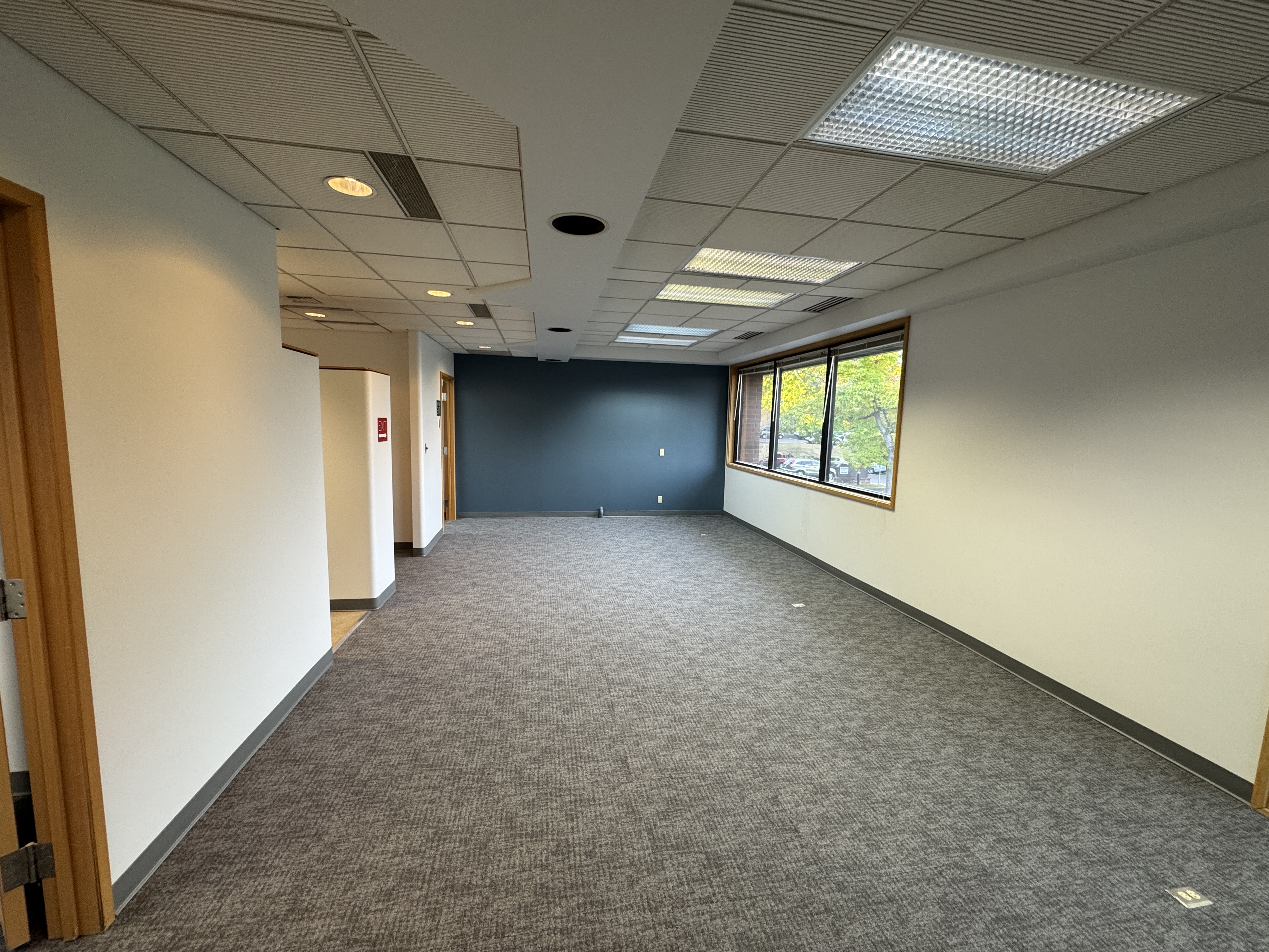 Finished open office with refreshed paint, new carpet and bay windows after tenant improvement