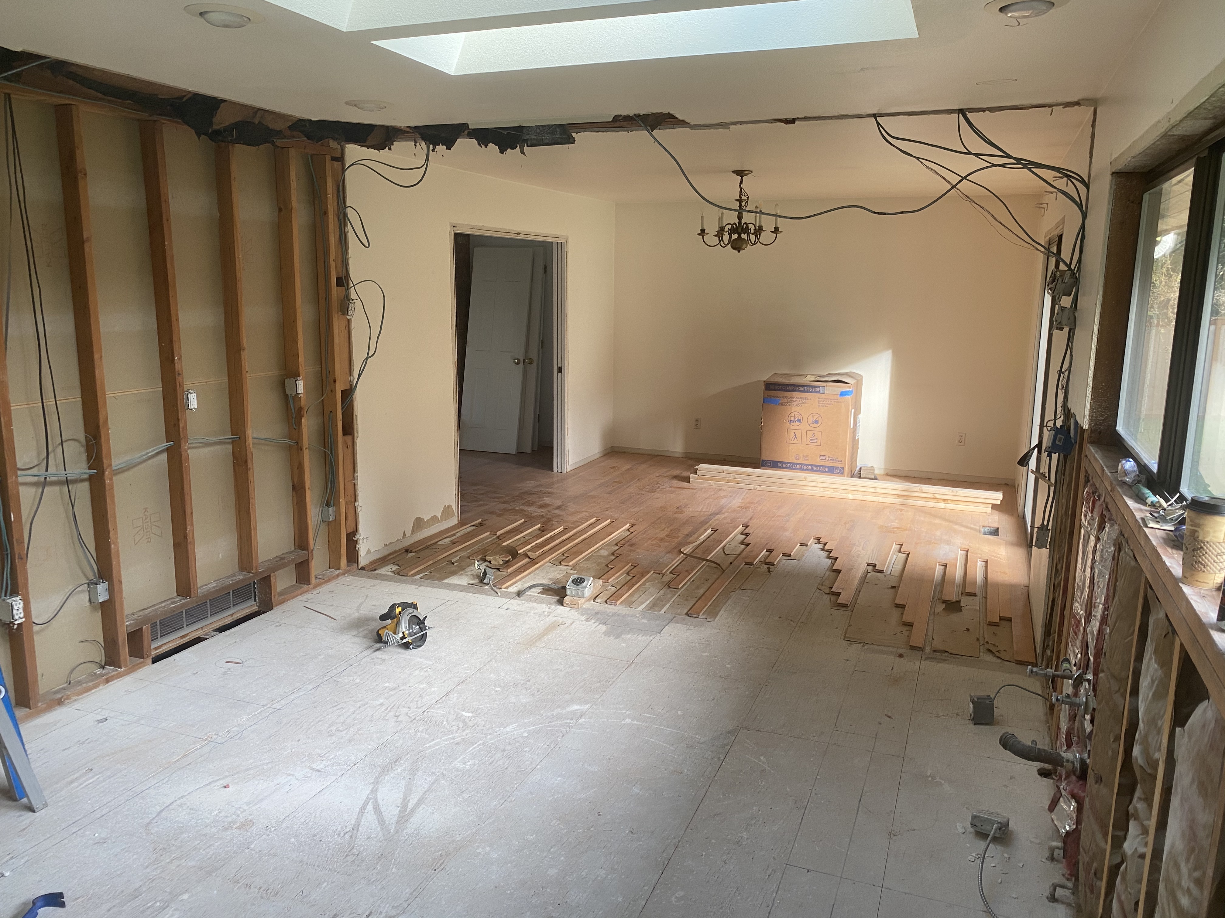 Before photo showing the interior stripped to the framing with exposed wall studs, subfloor, and electrical rough-in during the Issaquah remodel