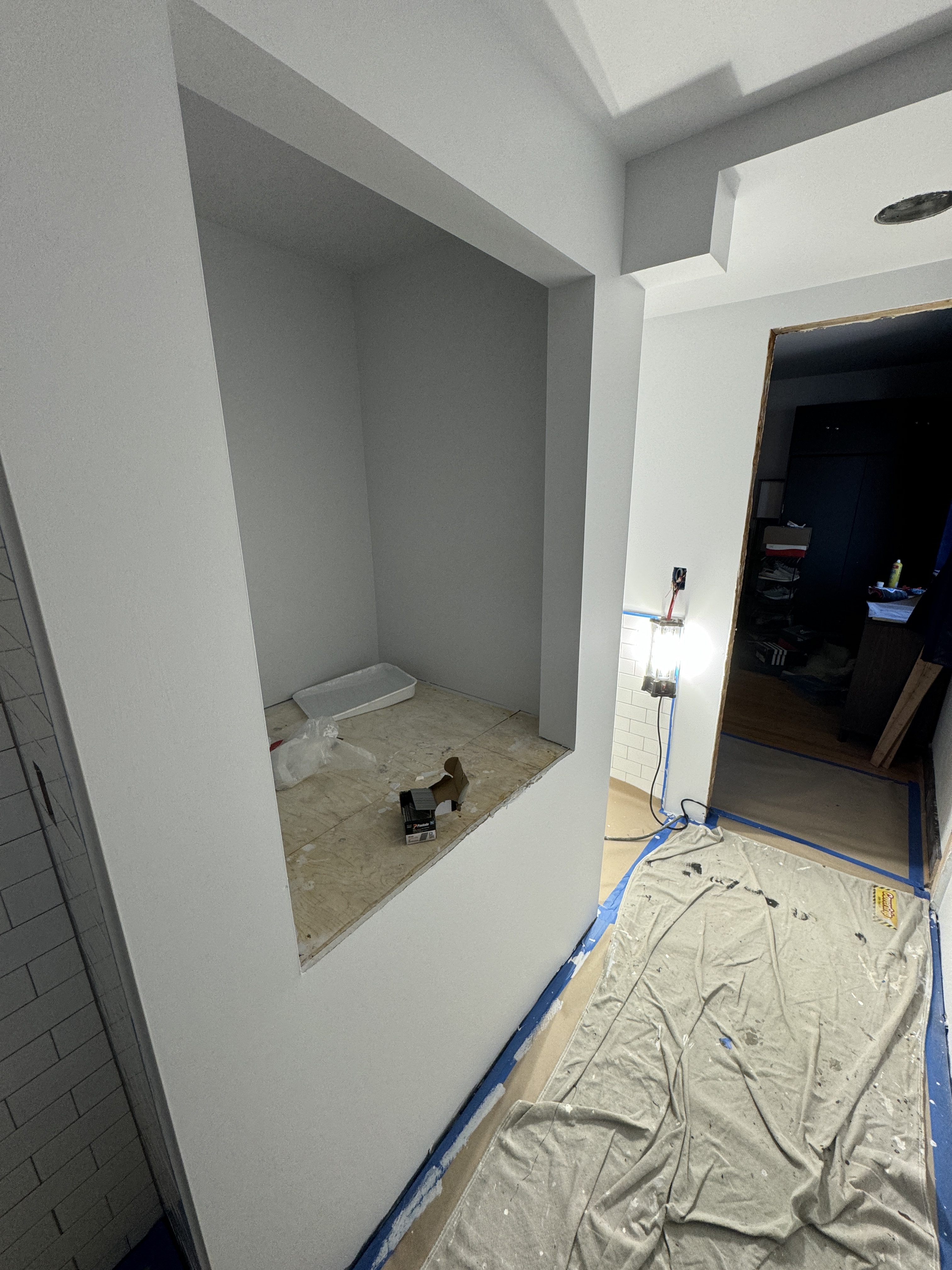 Bathroom rooms drywalled and primed with the built-in storage niche framed, ready for tile and finishes