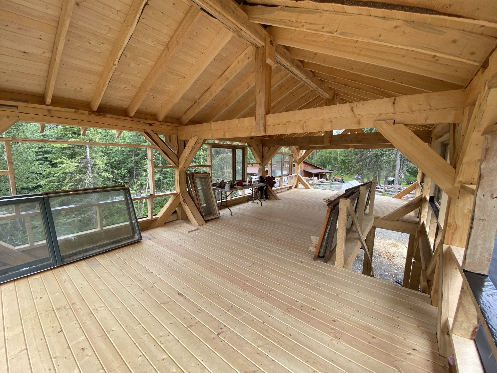 Detail of hand-carved timber knee brace and post-to-beam bracket joinery inside the barndominium