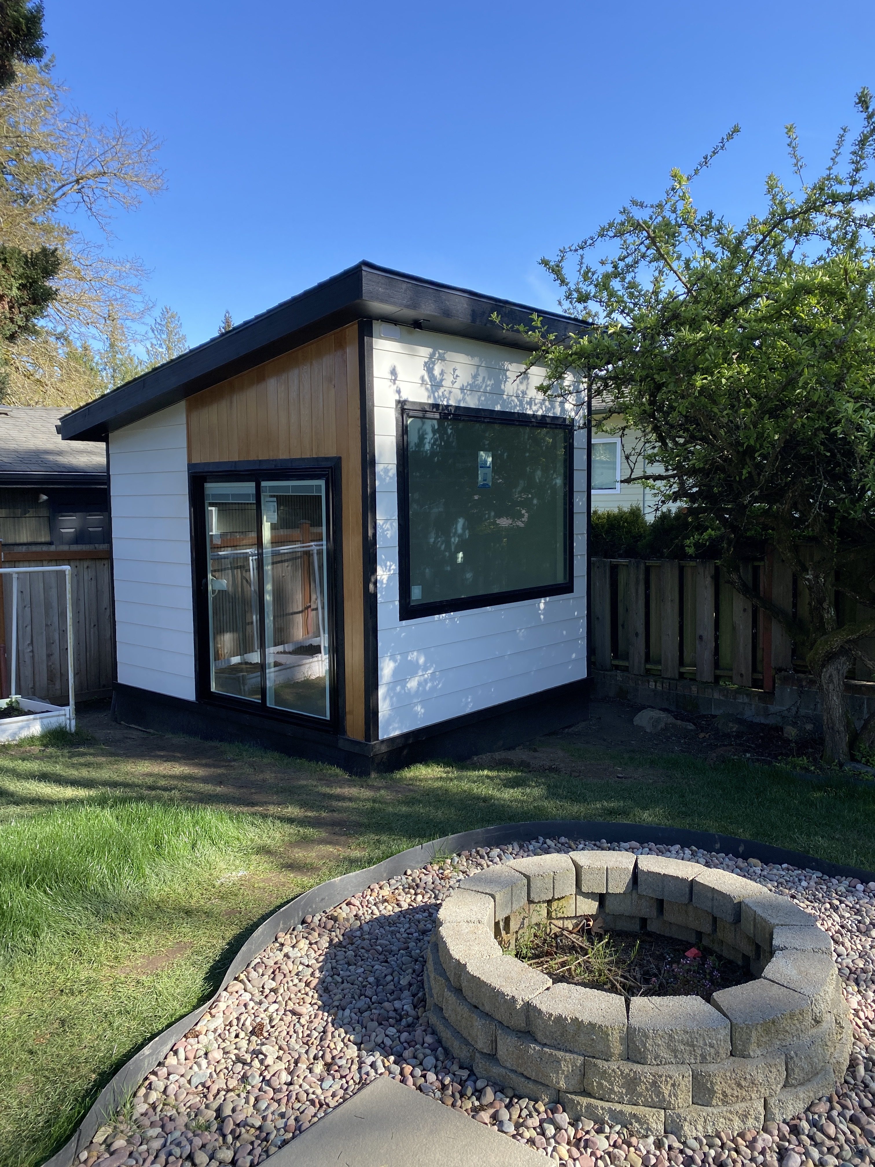 Detached backyard studio office with oversized glazing and slat ceiling
