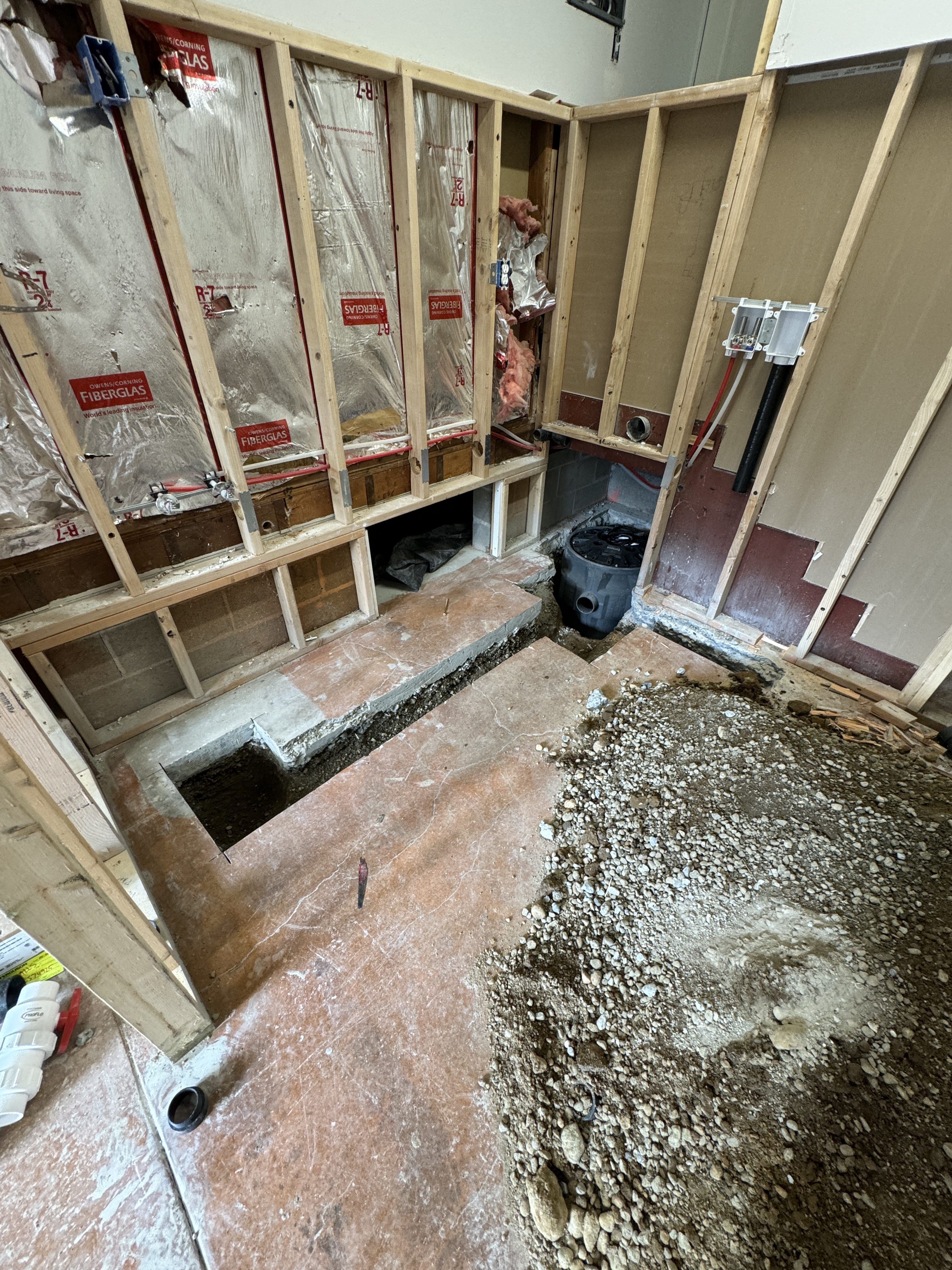 Interior of the finished Kenmore ADU showing light hardwood flooring, white bifold closet doors, and a view through to the bathroom and stacked laundry