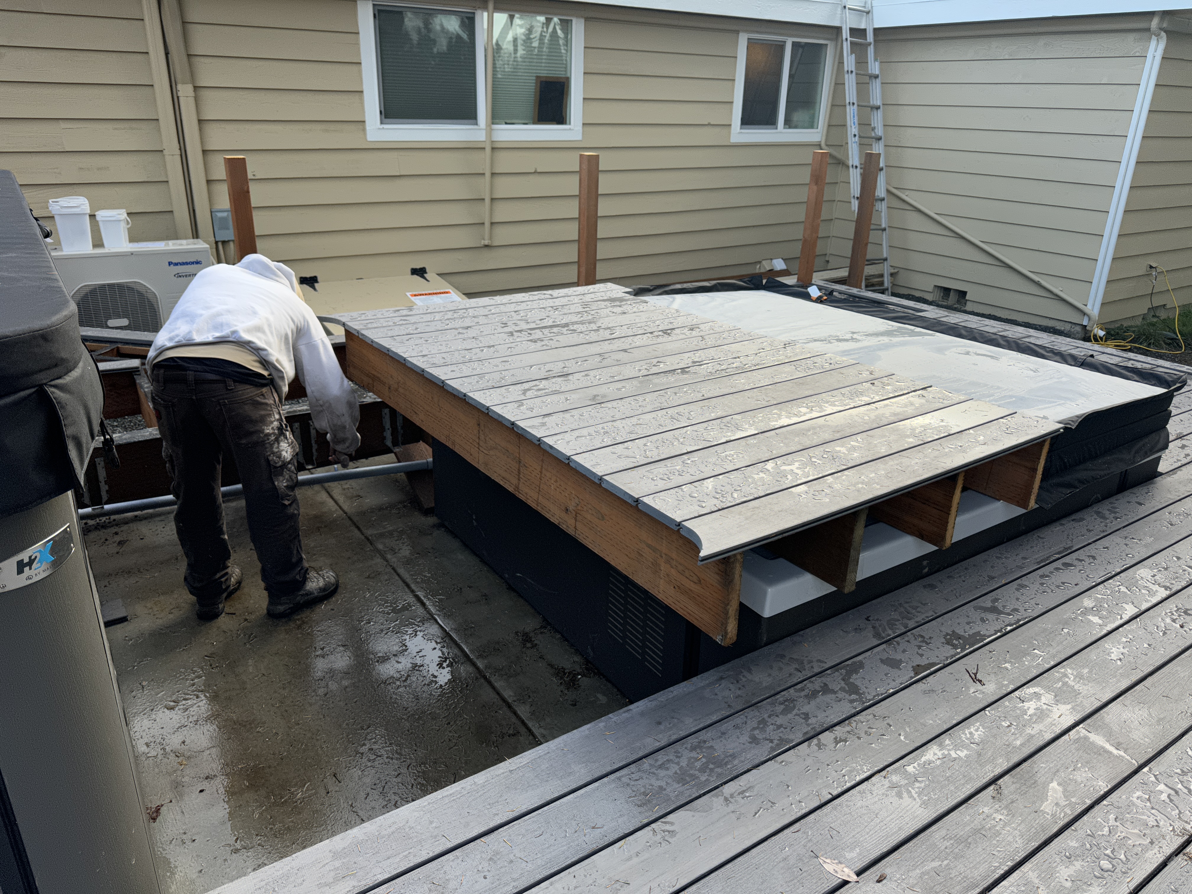 Composite decking being installed around the swim spa on a custom Kenmore deck