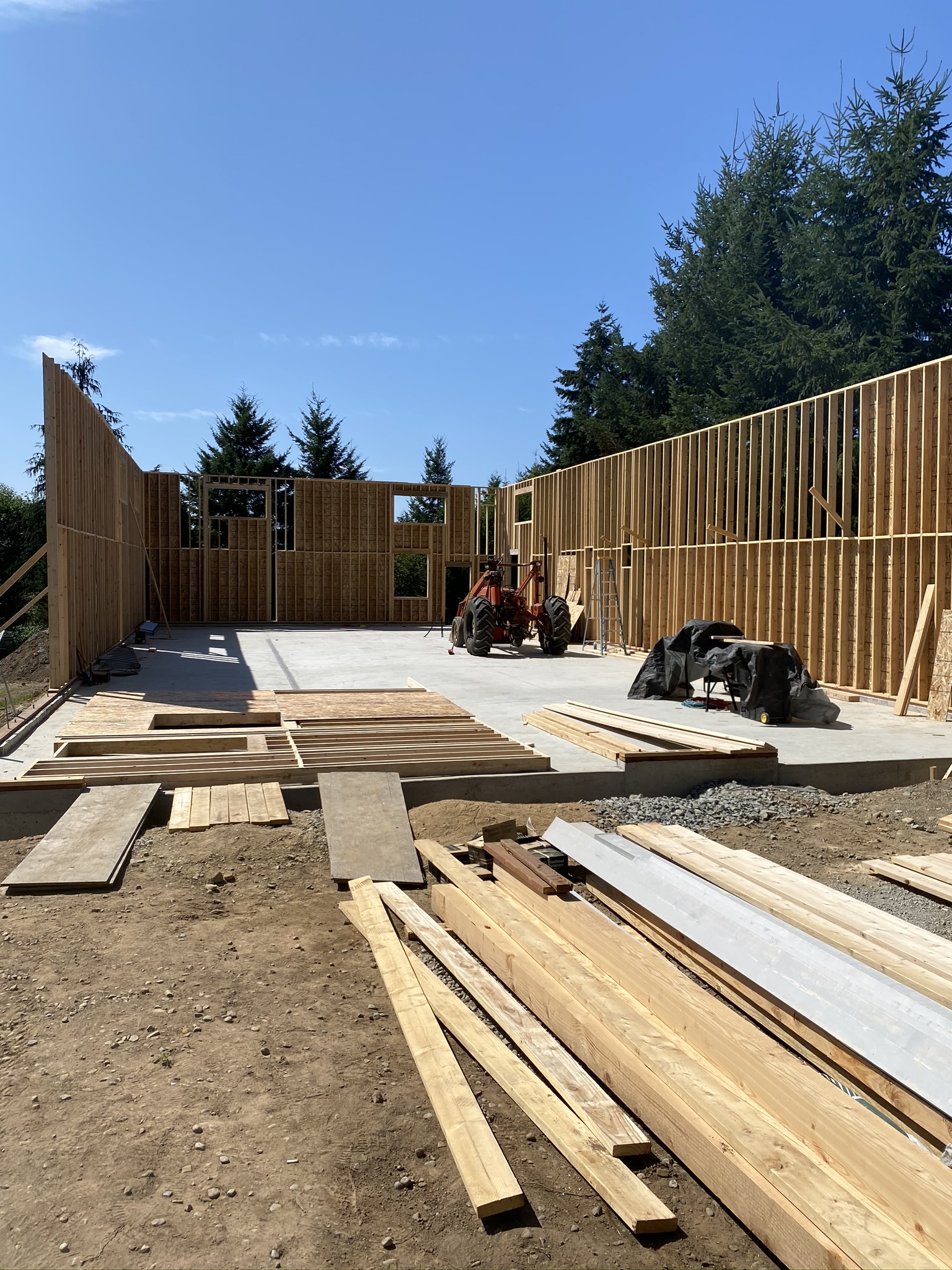 Crew framing tall wood-framed walls and oversized door headers on a new commercial shop in Monroe Washington
