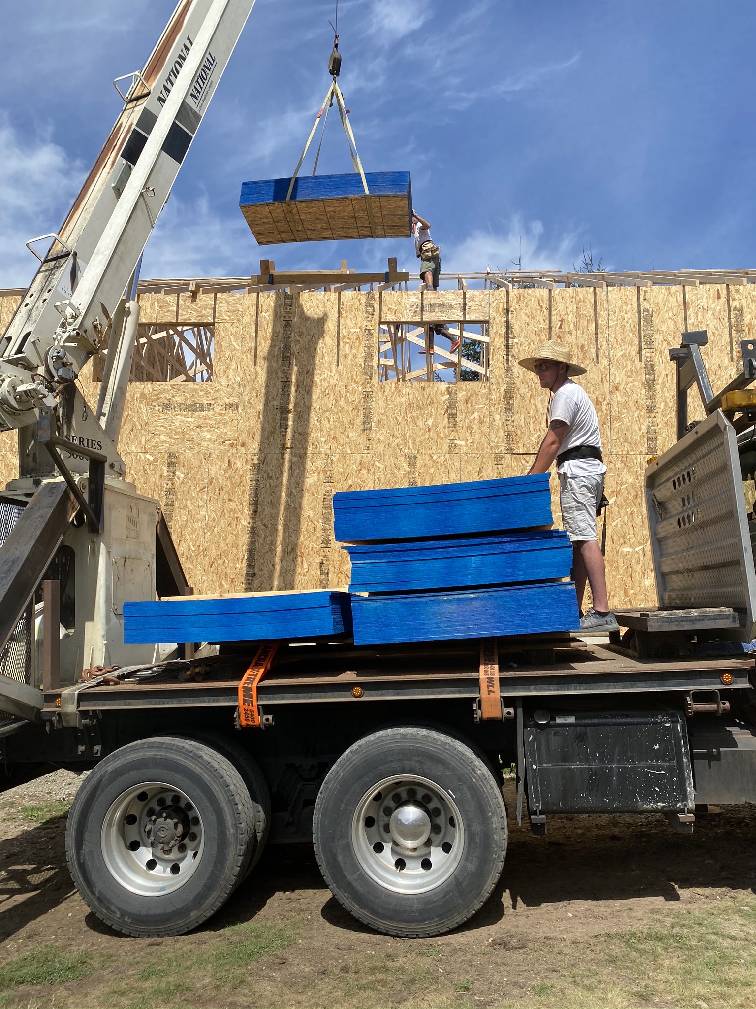 Engineered roof trusses being crane-set to clear-span a new commercial shop building in Monroe WA