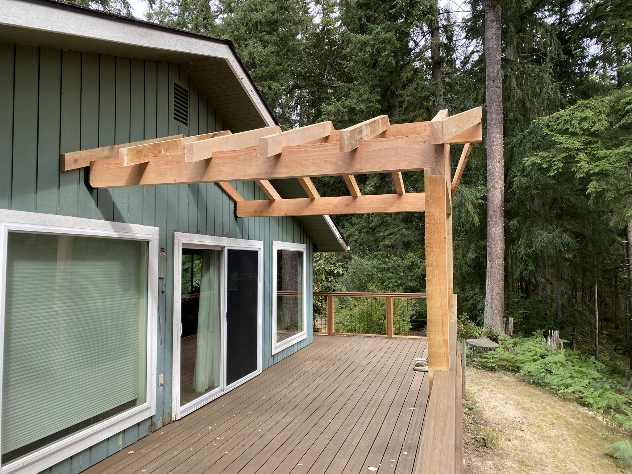 Composite decking installed and cedar patio cover framing underway during week two