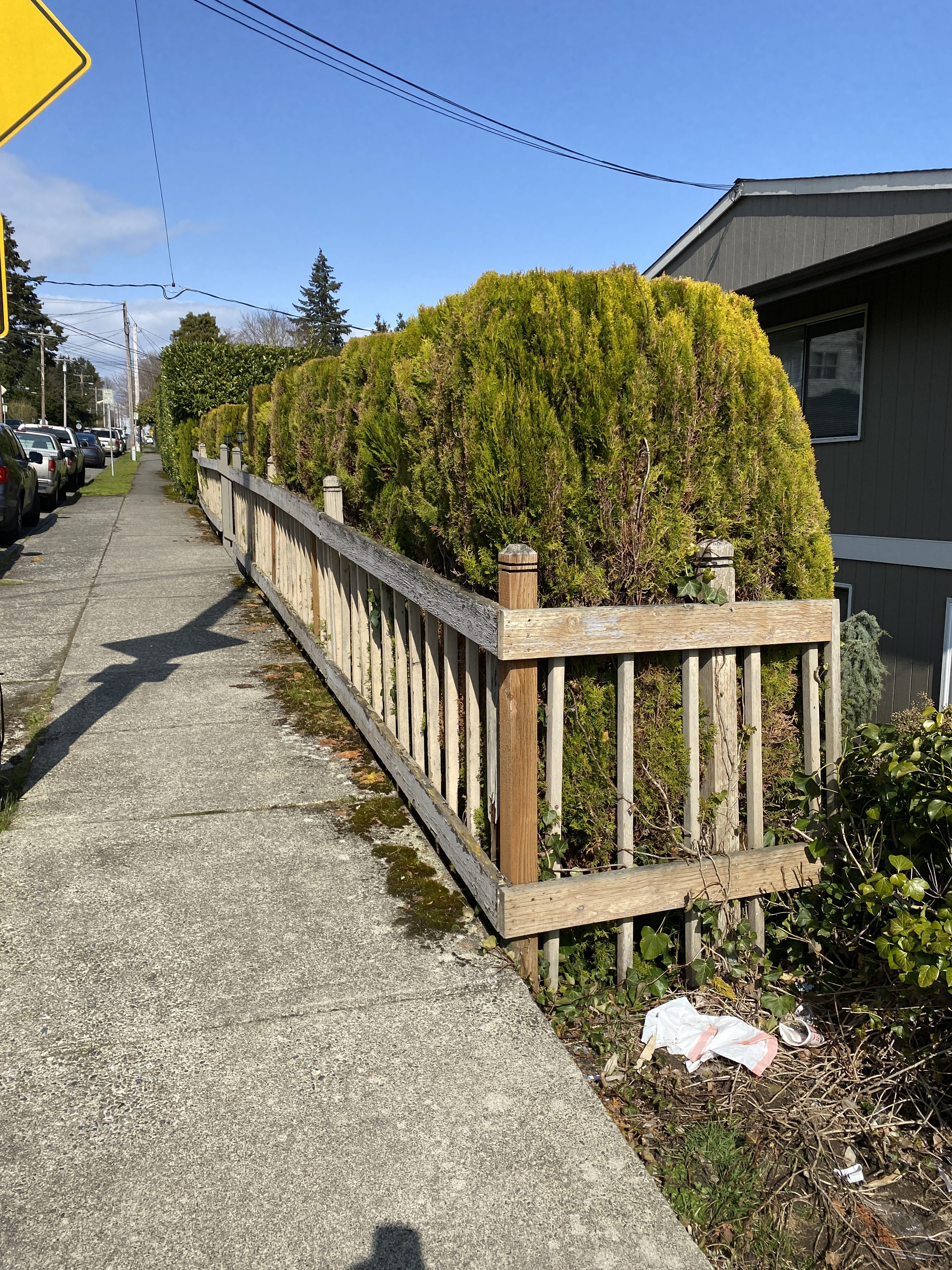 Deteriorated wood street fence before code-compliant replacement at the Juanita Hills multiplex, Kirkland