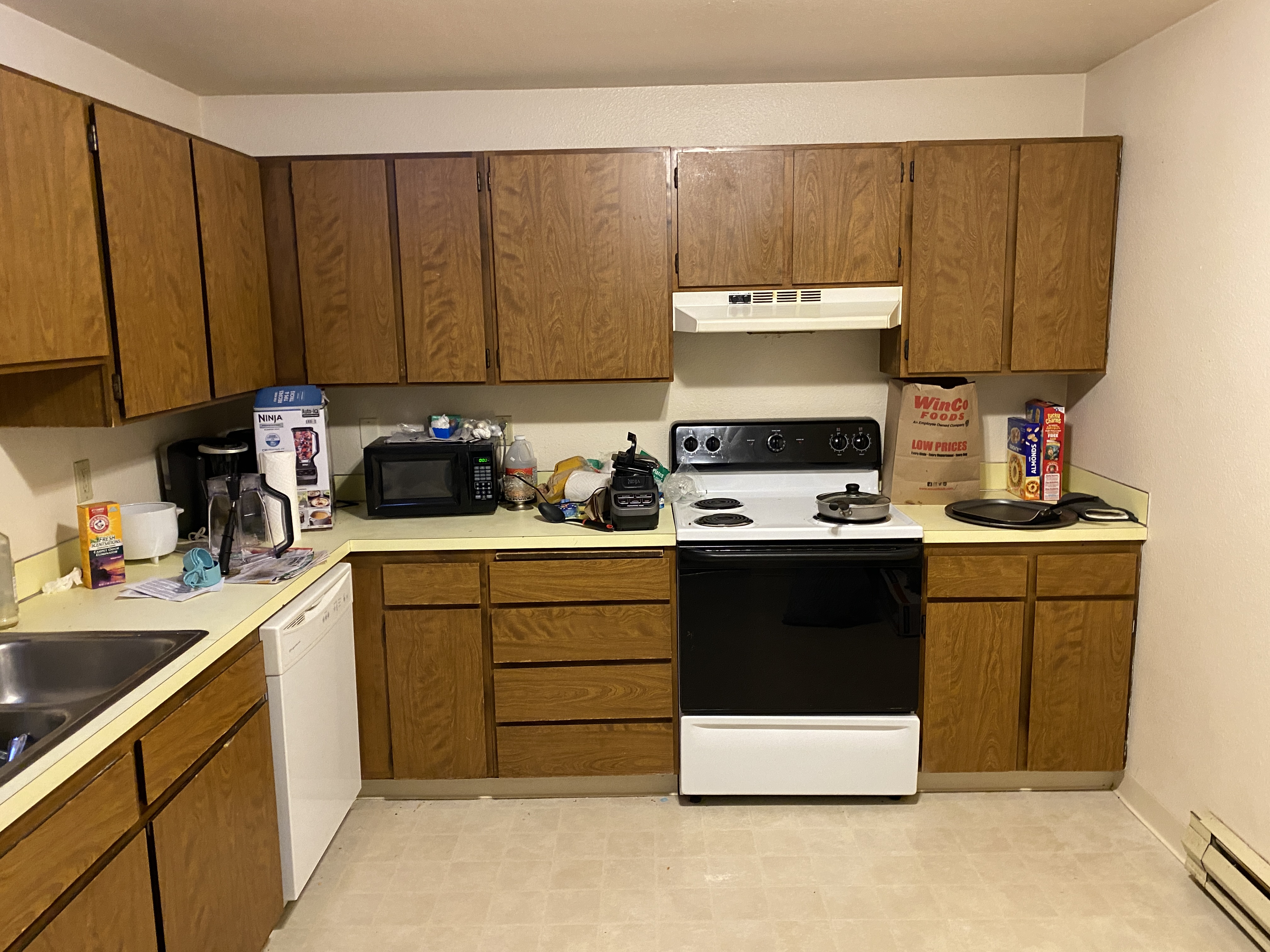 Dated apartment kitchen with brown cabinets before remodel in Kirkland