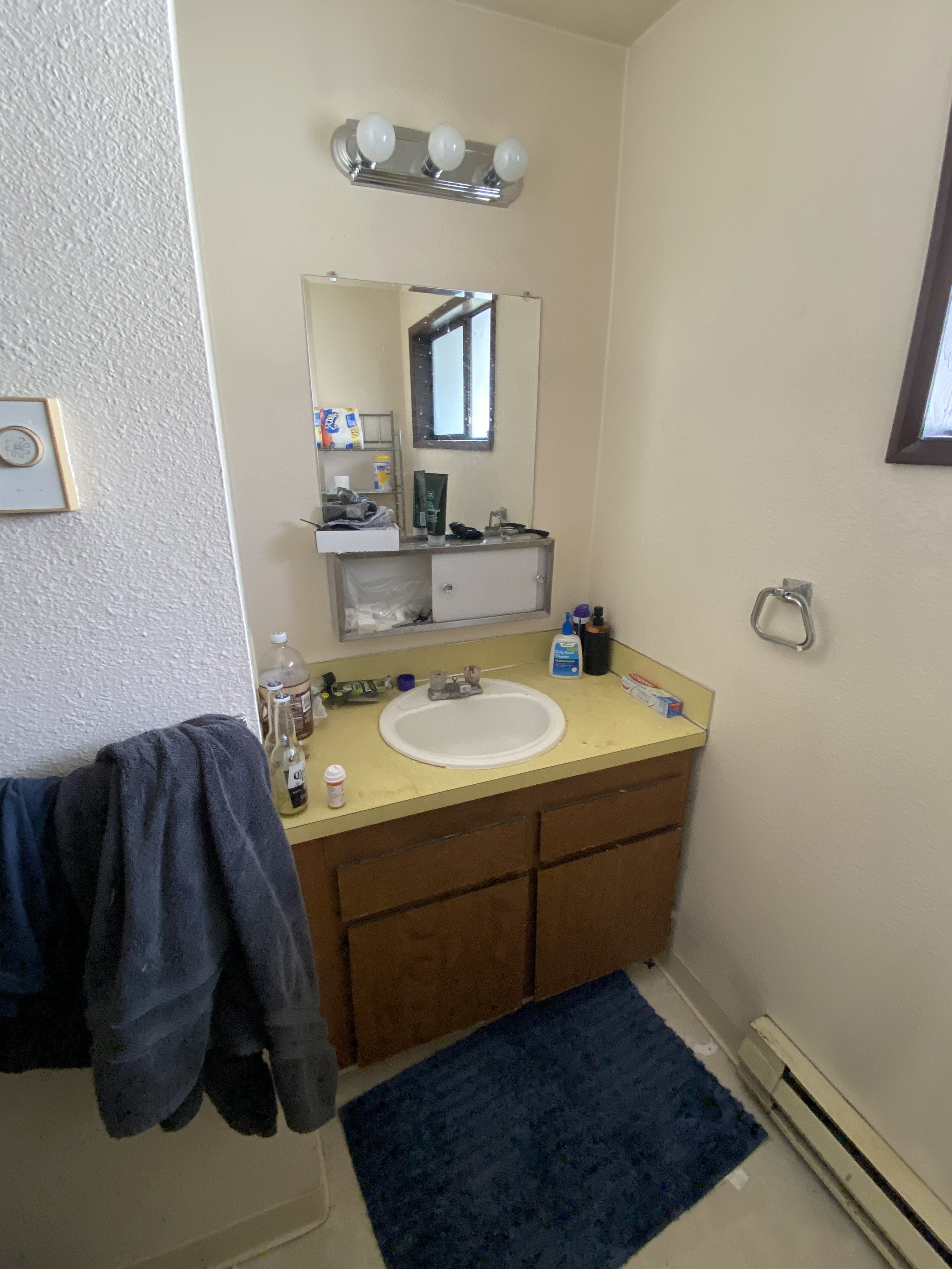 Original apartment bathroom vanity with yellow countertop before remodel in Kirkland