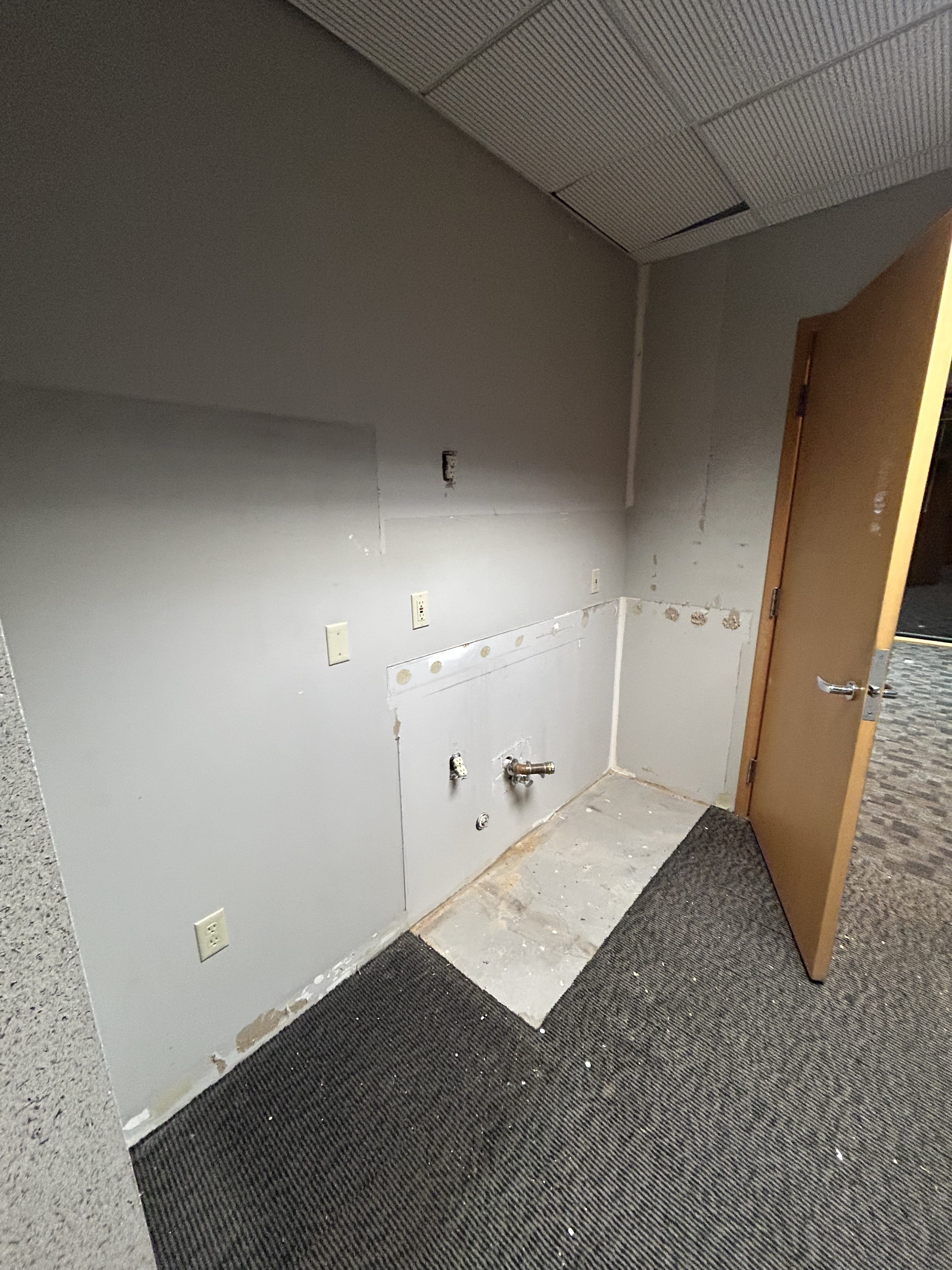 Capped plumbing stubs where dental sink was removed during tenant improvement demolition