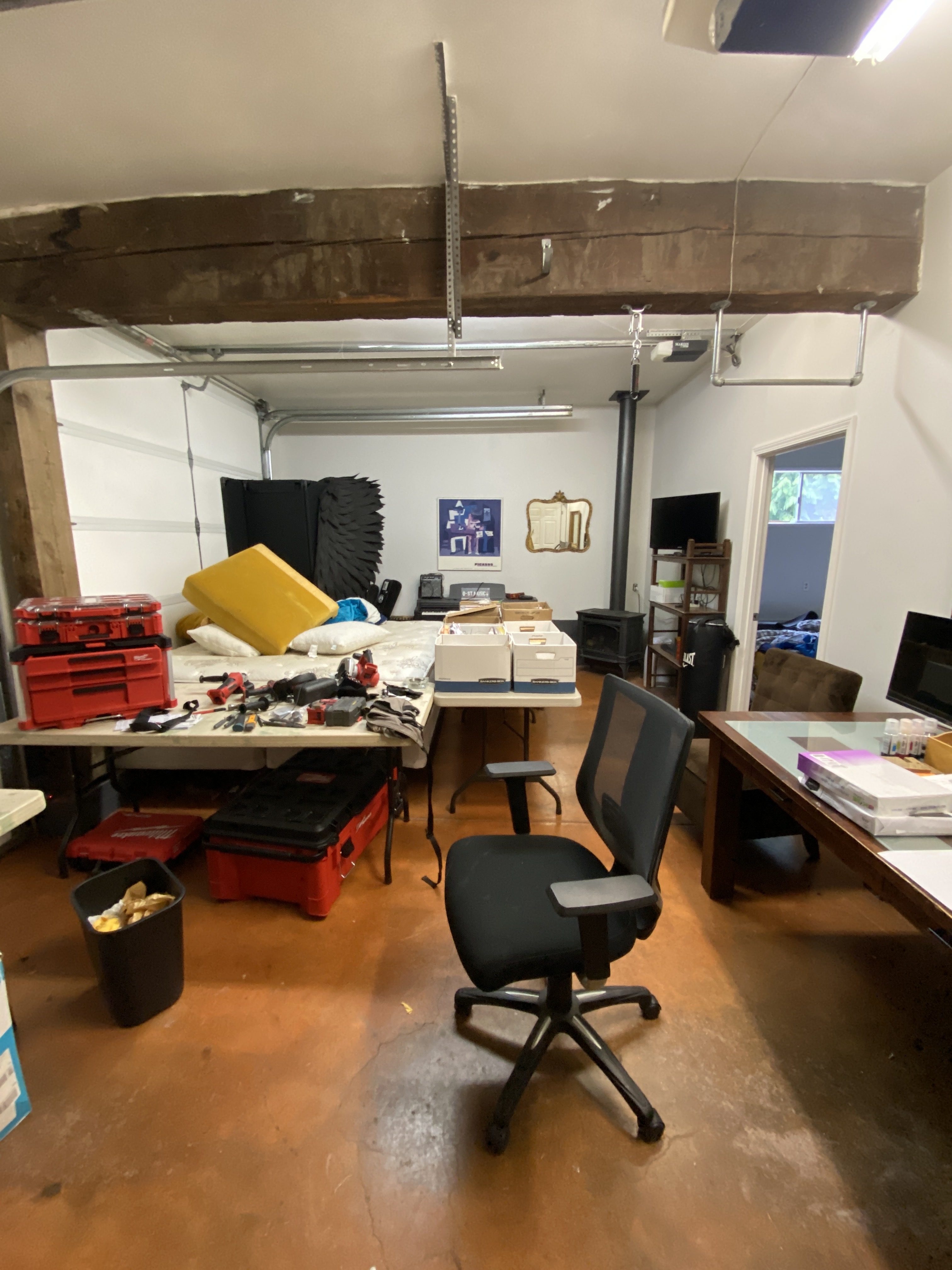 Attached two-car garage in Kenmore before the ADU conversion, used for storage with tool chests and an exposed gray ceiling beam