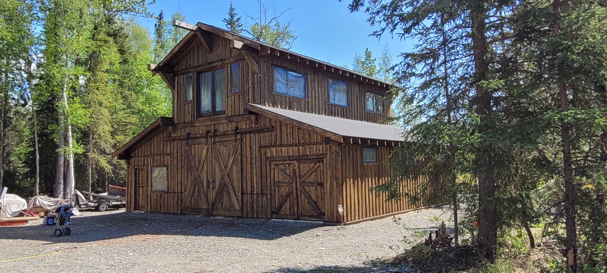 Completed hand-cut timber frame barndominium with stained board-and-batten siding in Snohomish, Washington